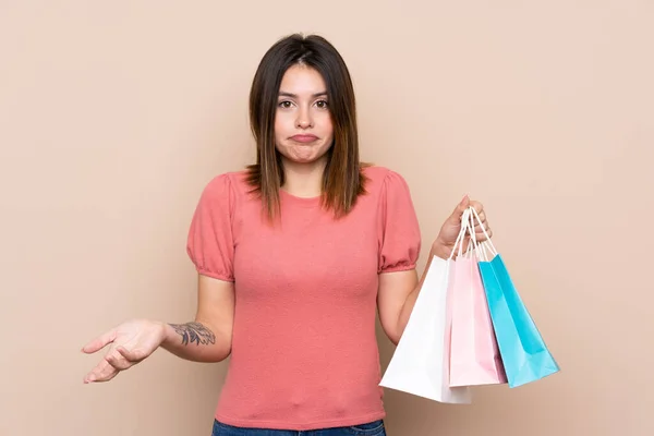 Young Woman Shopping Bag Isolated Background Making Doubts Gesture While — Stock Photo, Image