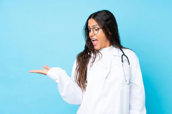Junge Ärztin Über Isoliertem Blauem Hintergrund Mit Imaginärem Kopierraum Auf — Stockfoto