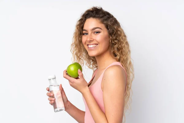 年轻的金发女人 卷曲的头发 白色背景 有一个苹果和一瓶水 — 图库照片