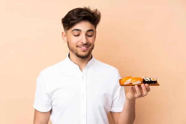 Hombre Árabe Comiendo Sushi Aislado Sobre Fondo Beige Con Expresión — Foto de Stock