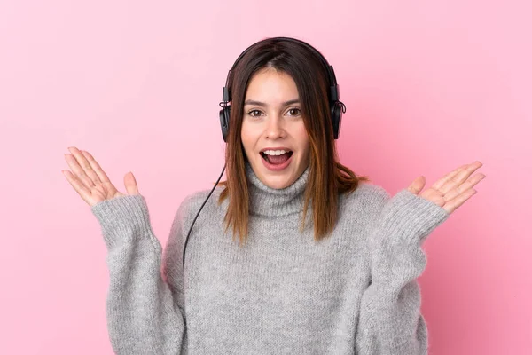 Zole Edilmiş Pembe Duvarda Kulaklıkla Müzik Dinleyen Genç Bir Kadın — Stok fotoğraf