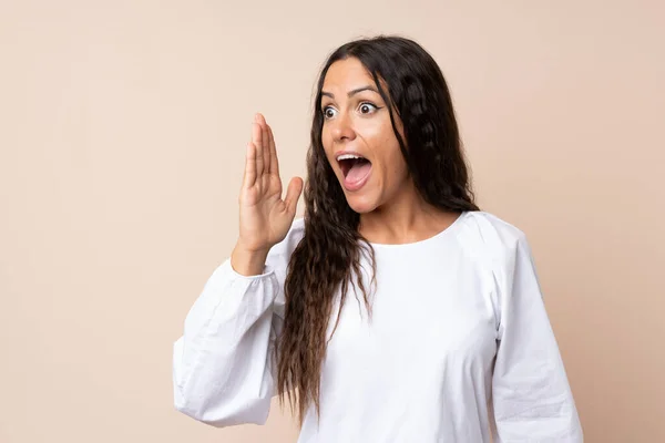 Young woman over isolated background shouting with mouth wide open