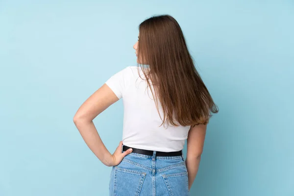 Adolescente Caucásico Chica Aislado Azul Fondo Espalda Posición Mirando Lado —  Fotos de Stock