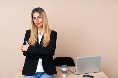 Ofisteki genç iş kadını kollarını kavuşturuyor.