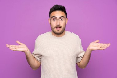 Yüzünde şok ifadesi olan, soyutlanmış, mor bir geçmişi olan genç yakışıklı bir adam.