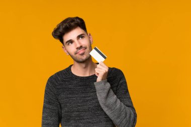 Soyutlanmış bir geçmişi olan genç bir adam kredi kartı tutuyor.