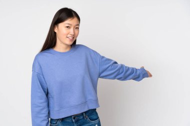 Genç Asyalı kadın arka planda izole edilmiş. Davet edilmek için ellerini yana uzatıyor.