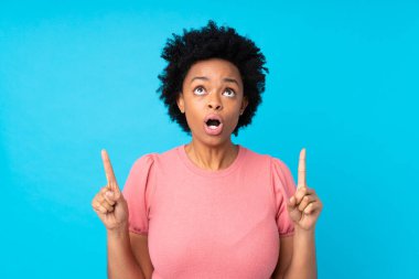 İzole edilmiş mavi arka planda Afro-Amerikalı kadın işaret parmağıyla işaret etmek harika bir fikir.