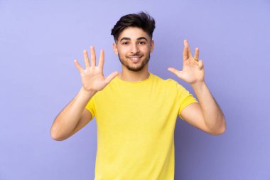 İzole edilmiş arka planda yaşayan Arap yakışıklı adam parmaklarıyla dokuz kişi sayıyor.