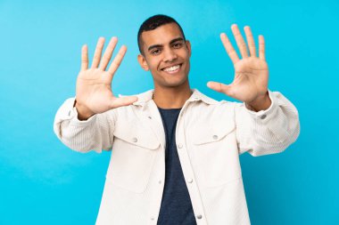 İzole edilmiş mavi arka planda on parmaklı genç Afrikalı Amerikalı adam.