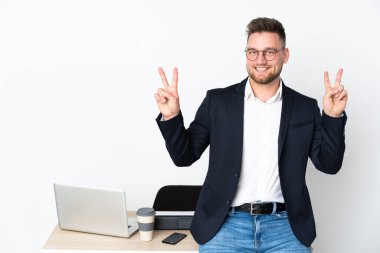 Beyaz arka planda izole edilmiş bir ofiste Rus bir adam zafer işaretini iki eliyle gösteriyor.