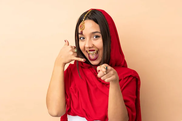 Jeune Indienne Isolée Sur Fond Beige Faisant Geste Téléphonique Pointant — Photo