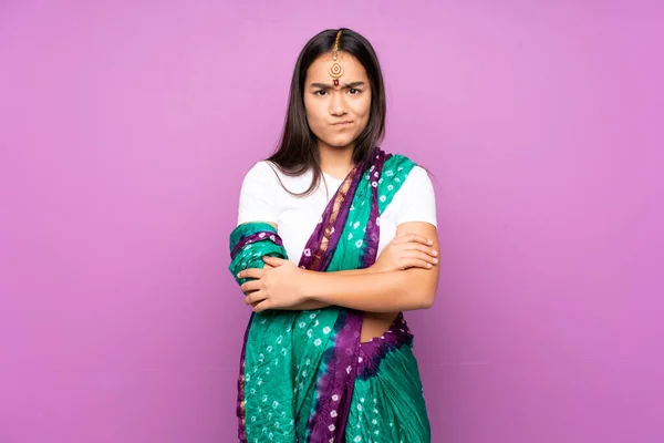 Young Indian woman with sari over isolated background feeling upset