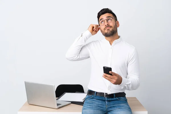 Joven Hombre Negocios Sosteniendo Teléfono Móvil Que Tiene Dudas Con — Foto de Stock