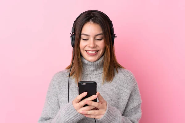 Jeune Femme Écoutant Musique Avec Écouteurs Sur Mur Rose Isolé — Photo