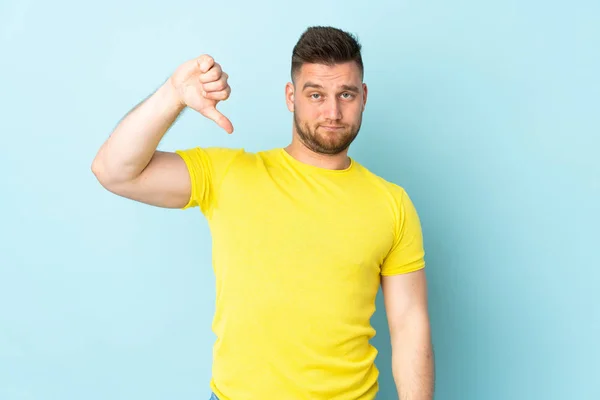 Rysk Stilig Man Isolerad Blå Bakgrund Visar Tummen Ner Med — Stockfoto