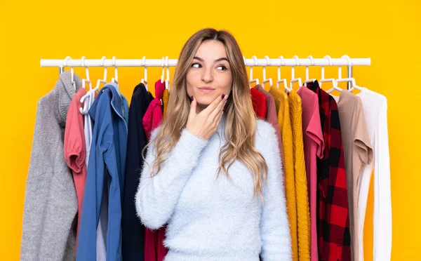 Giovane Donna Negozio Abbigliamento Sfondo Giallo Isolato Pensando Idea — Foto Stock