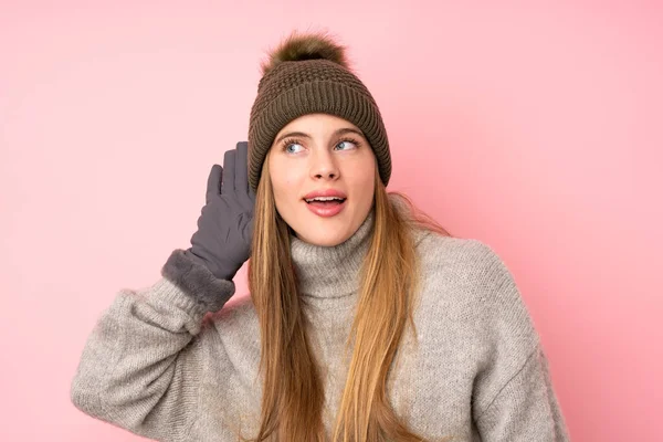 Mladý Teenager Dívka Zimní Klobouk Přes Izolované Růžové Pozadí Poslech — Stock fotografie
