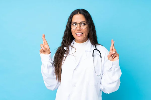 Junge Ärztin Vor Isoliertem Blauen Hintergrund Mit Daumendrücken — Stockfoto