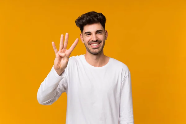 Mladý Muž Nad Izolované Oranžové Pozadí Šťastný Počítání Čtyři Prsty — Stock fotografie