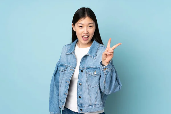 Junge Asiatin Isoliert Hintergrund Lächelnd Und Mit Siegeszeichen — Stockfoto
