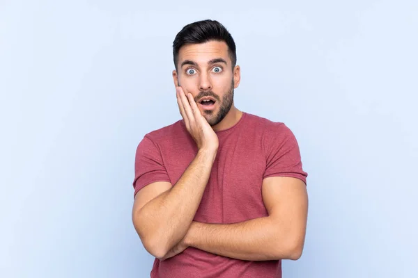 Junger Gutaussehender Mann Mit Bart Vor Isoliertem Blauen Hintergrund Überrascht — Stockfoto