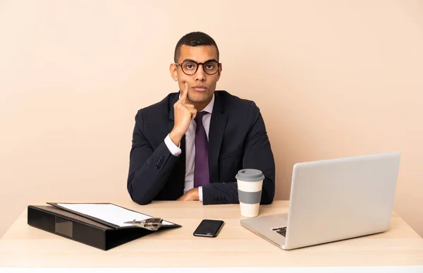 stock image Young business man in his office with a laptop and other documents and looking front