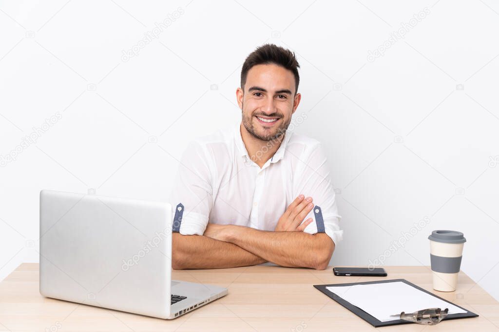 Young business man with a mobile phone in a workplace laughing