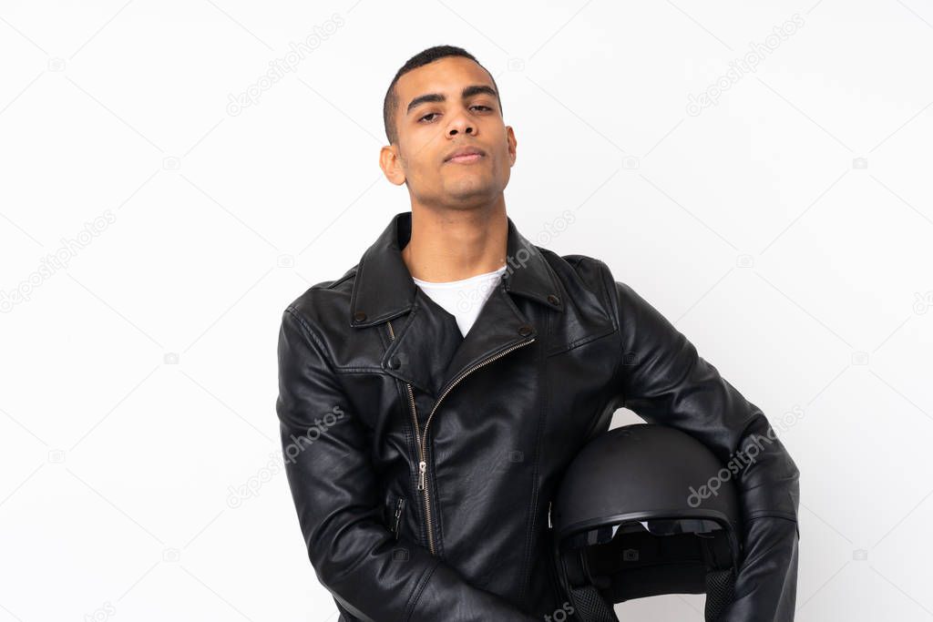 Young handsome man with a motorcycle helmet over isolated white background keeping arms crossed