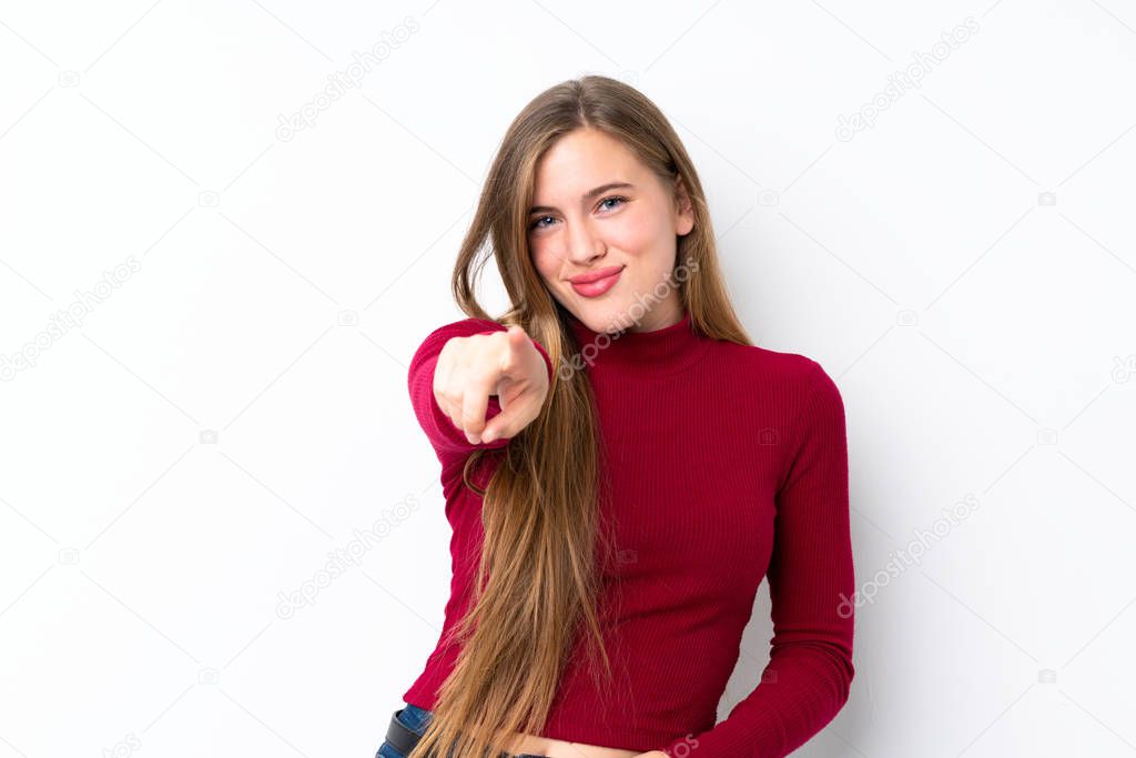 Teenager blonde girl over isolated white background points finger at you with a confident expression