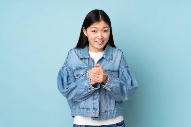 Genç Asyalı kadın arka planda yalnız gülüyor.