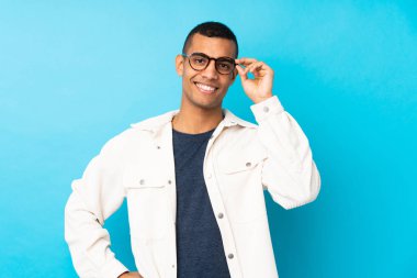 Gözlüklü ve mutlu, soyutlanmış mavi bir geçmişi olan genç bir Afro-Amerikalı.