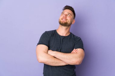 Soyutlanmış bir geçmişe sahip Rus yakışıklı bir adam gülümserken yukarı bakıyor.