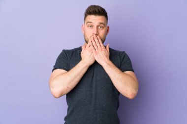 İzole edilmiş arka plan üzerinde Rus yakışıklı adam elleriyle ağzını kapatıyor.