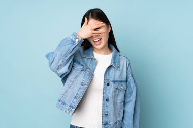 Asyalı genç bir kadın arka planda izole edilmiş, gözleri kapalı ve gülümsüyor.