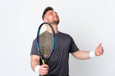 Beyaz arka planda izole edilmiş Rus yakışıklı bir adam tenis oynuyor ve zaferi kutluyor.