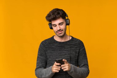 Genç adam kulaklıklı cep telefonunu kullanarak izole edilmiş.
