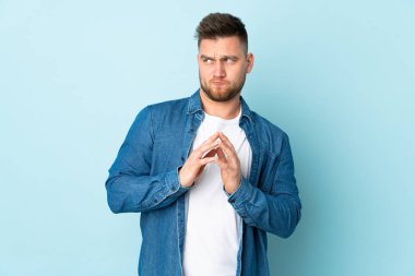 Rus yakışıklı adam mavi arka planda bir şeyler çeviriyor.