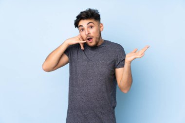 Arap yakışıklı adam izole edilmiş arka planda telefon jesti yapıyor ve kuşkulanıyor