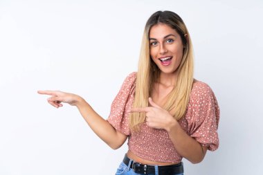 Genç Uruguaylı kadın soyutlanmış beyaz arka planda şaşırmış ve işaret ediyor