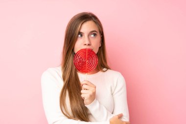 Kar kayağı gözlüklü genç kız izole edilmiş pembe arka planda.