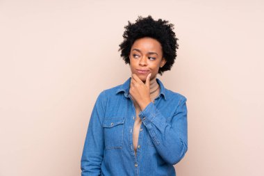 Afrikalı Amerikalı kadın izole edilmiş arka planda bir fikir düşünüyor.