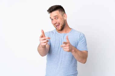 İzole edilmiş arka plan üzerinde Rus yakışıklı bir adam ön tarafı işaret ediyor ve gülümsüyor.
