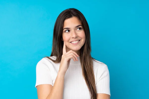 Tiener Meisje Geïsoleerde Blauwe Achtergrond Denken Een Idee Terwijl Zoek — Stockfoto