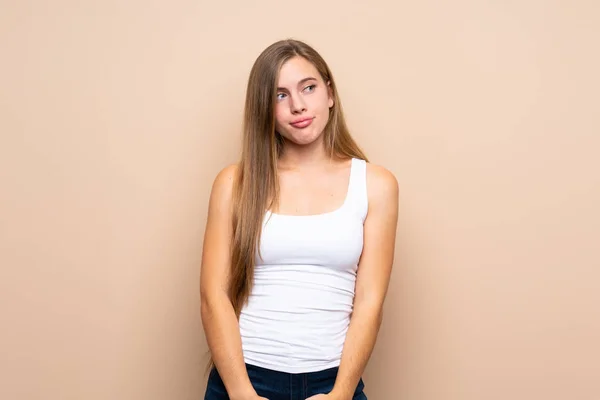 Teenager Ξανθιά Κοπέλα Πάνω Από Απομονωμένη Φόντο Κάνοντας Χειρονομία Αμφιβολιών — Φωτογραφία Αρχείου
