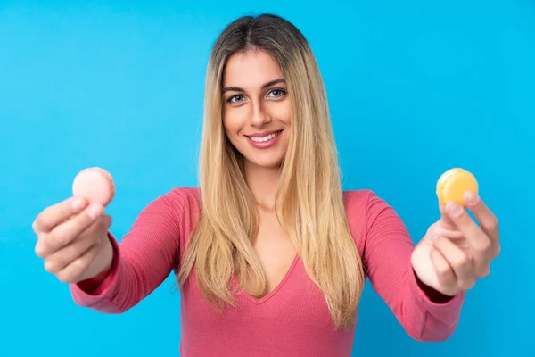 Jonge Uruguayaanse Vrouw Geïsoleerde Blauwe Achtergrond Met Kleurrijke Franse Macarons — Stockfoto