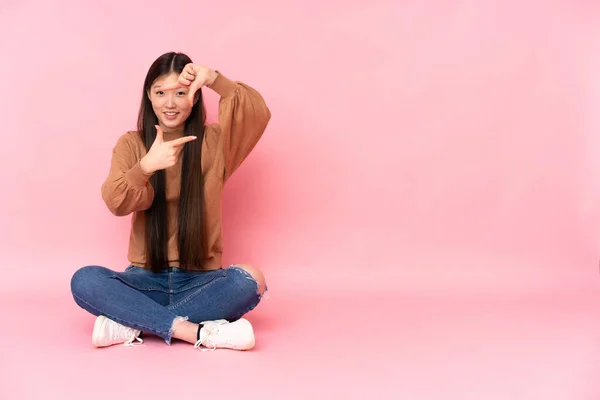 Young Asian Woman Sitting Floor Isolated Pink Background Focusing Face — Stock Photo, Image