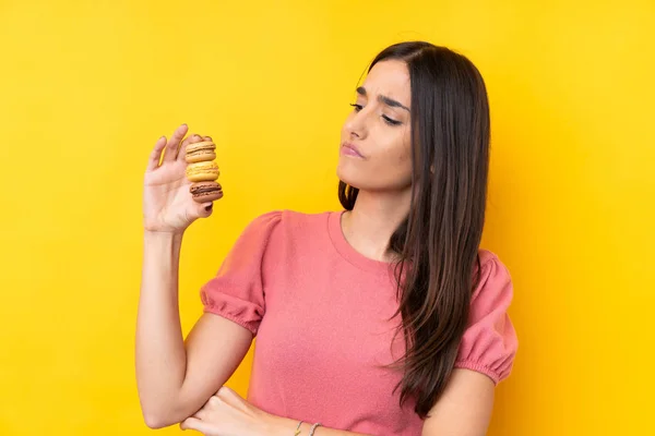 Giovane Donna Bruna Sfondo Giallo Isolato Con Macaron Francesi Colorati — Foto Stock