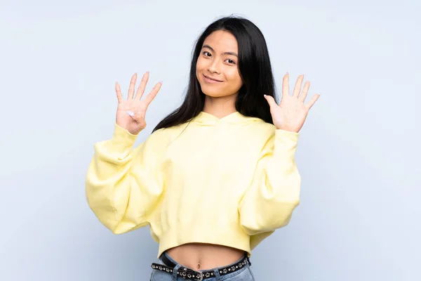 Mavi Arka Planda Izole Edilmiş Genç Çinli Kadın Parmaklarıyla Dokuza — Stok fotoğraf