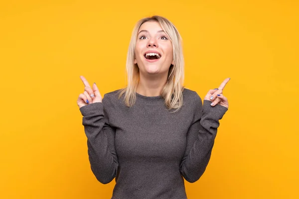 Giovane Donna Bionda Sfondo Giallo Isolato Sorpreso Indicando — Foto Stock